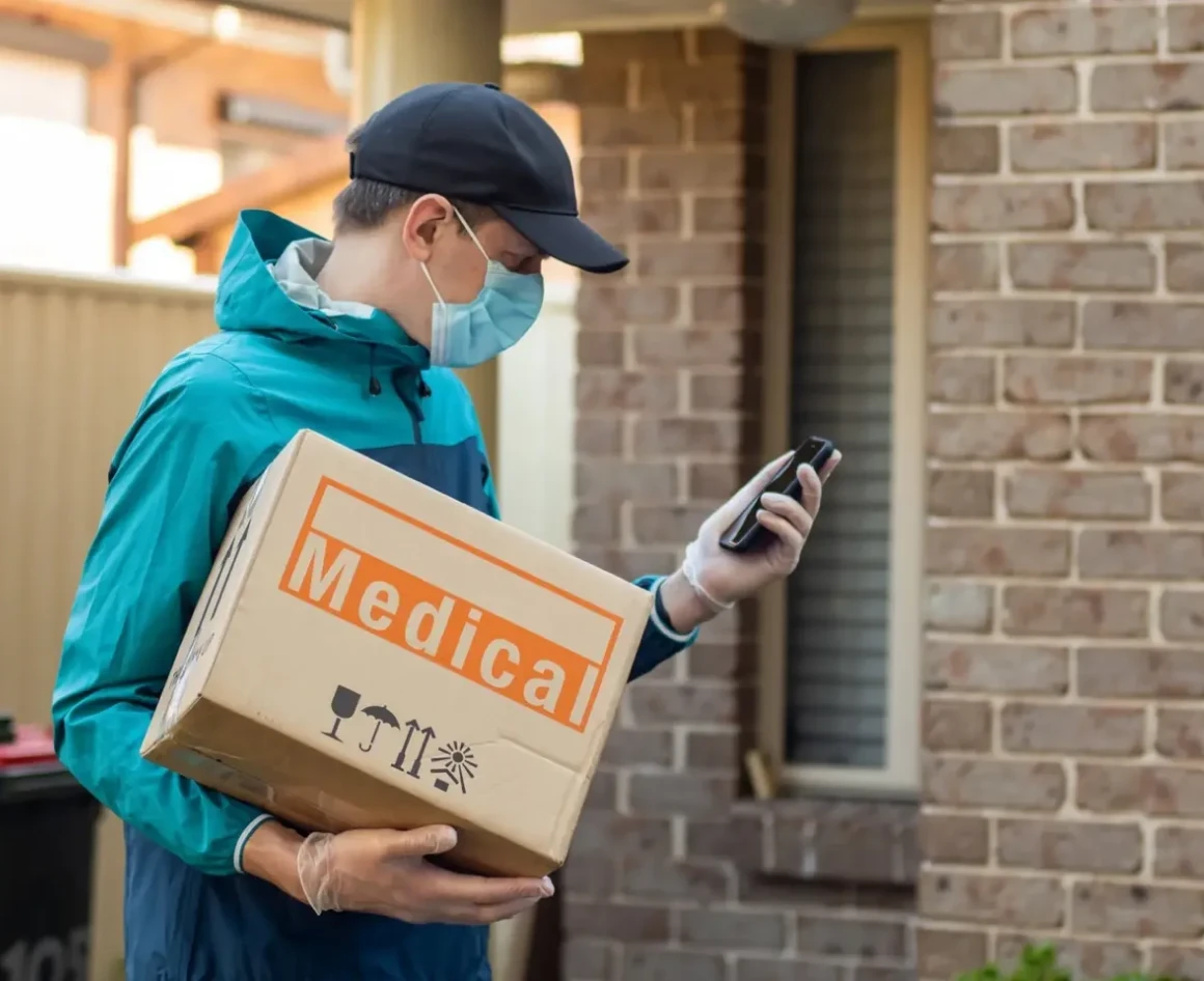 Man checking phone while holding medical parcel