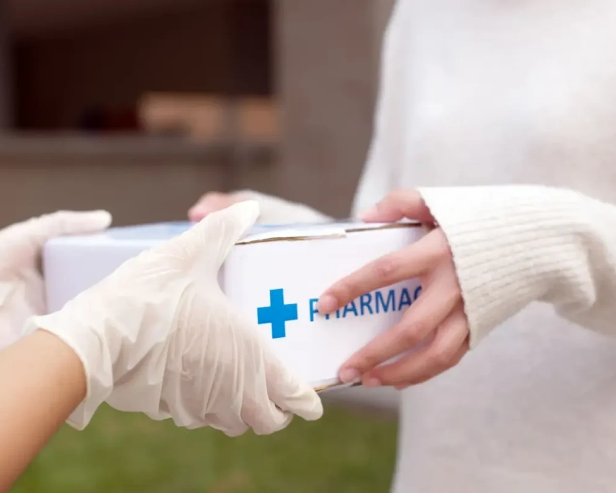 Hands exchanging a pharmacy package