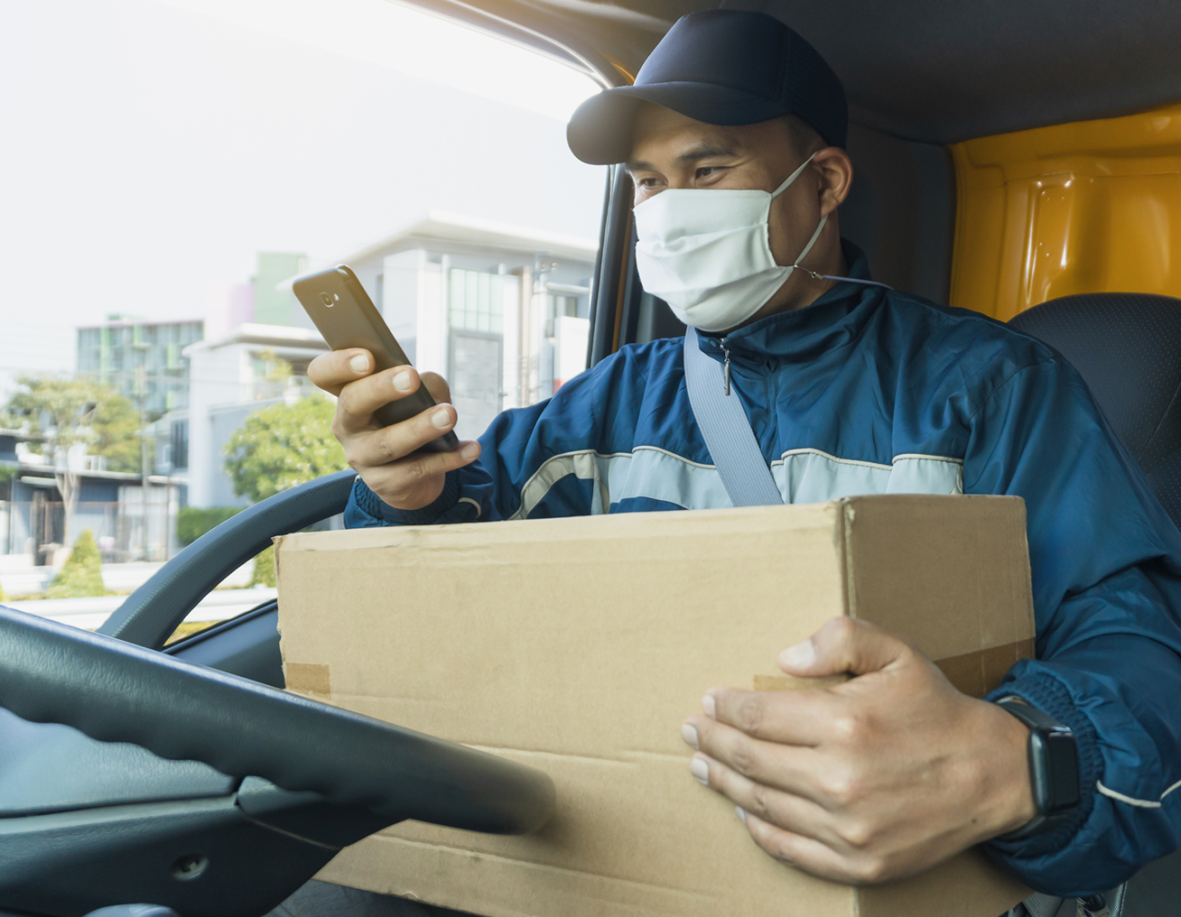 Courier checking phone inside vehicle